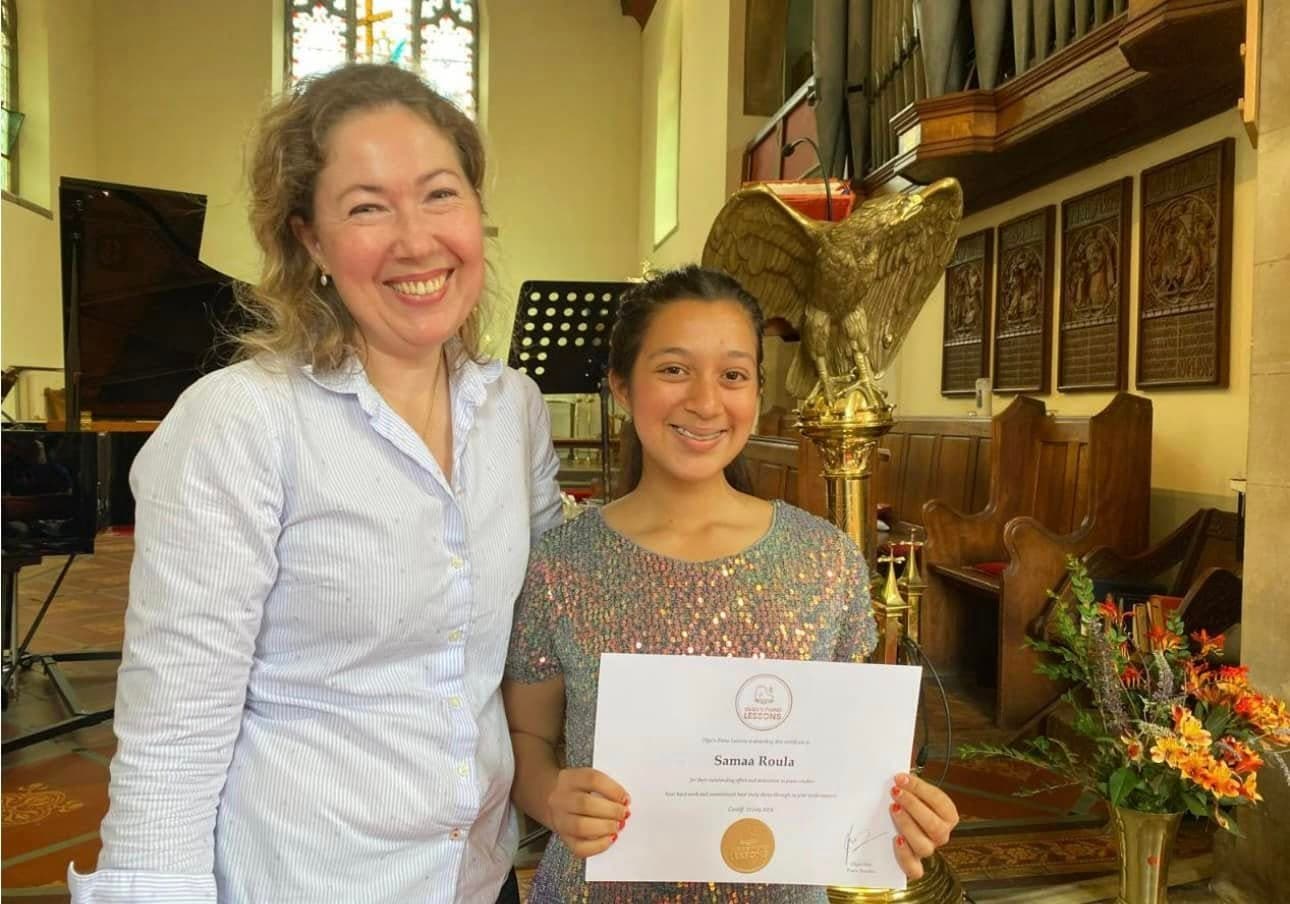 A teacher and student with an achievement certificate