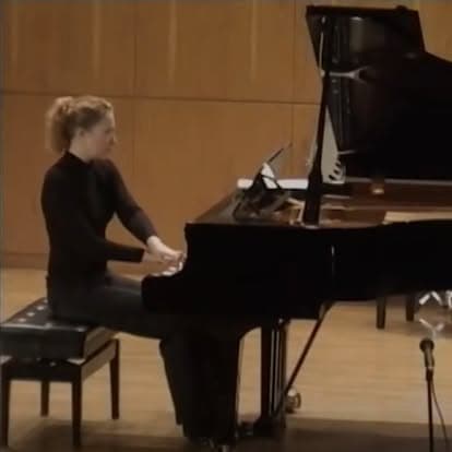 A pianist performing at a grand piano