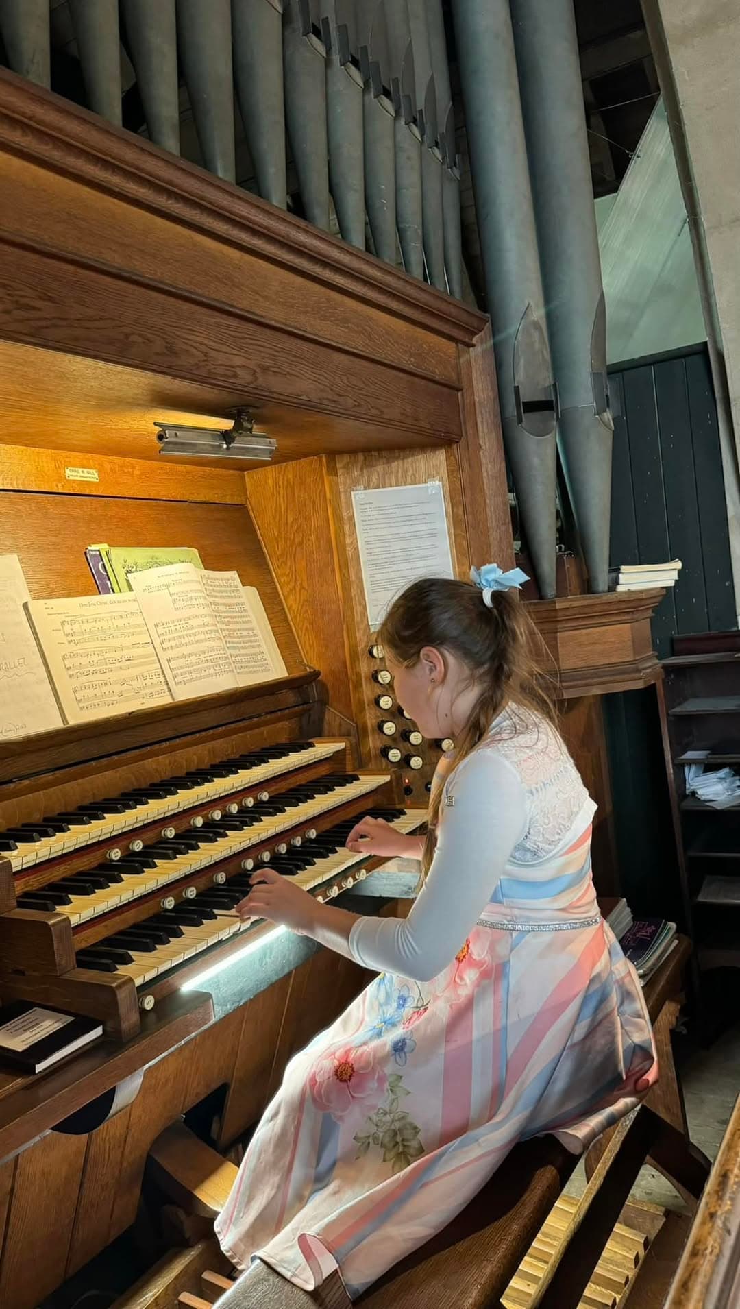 A young musician at a church pipe organ