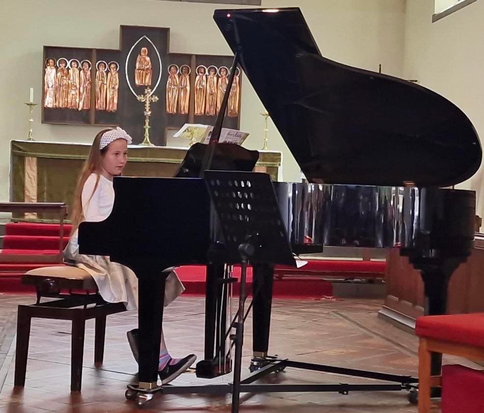 A young pianist performing on a grand piano